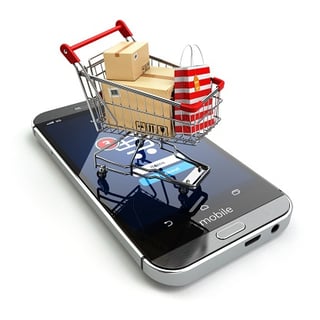 mini shopping cart sitting on top of mobile phone