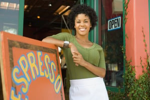 small_business_owner_standing_outside_shop-woman_in_apron