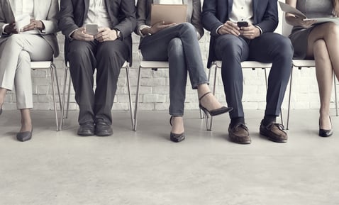row of hiring candidates sitting in chairs